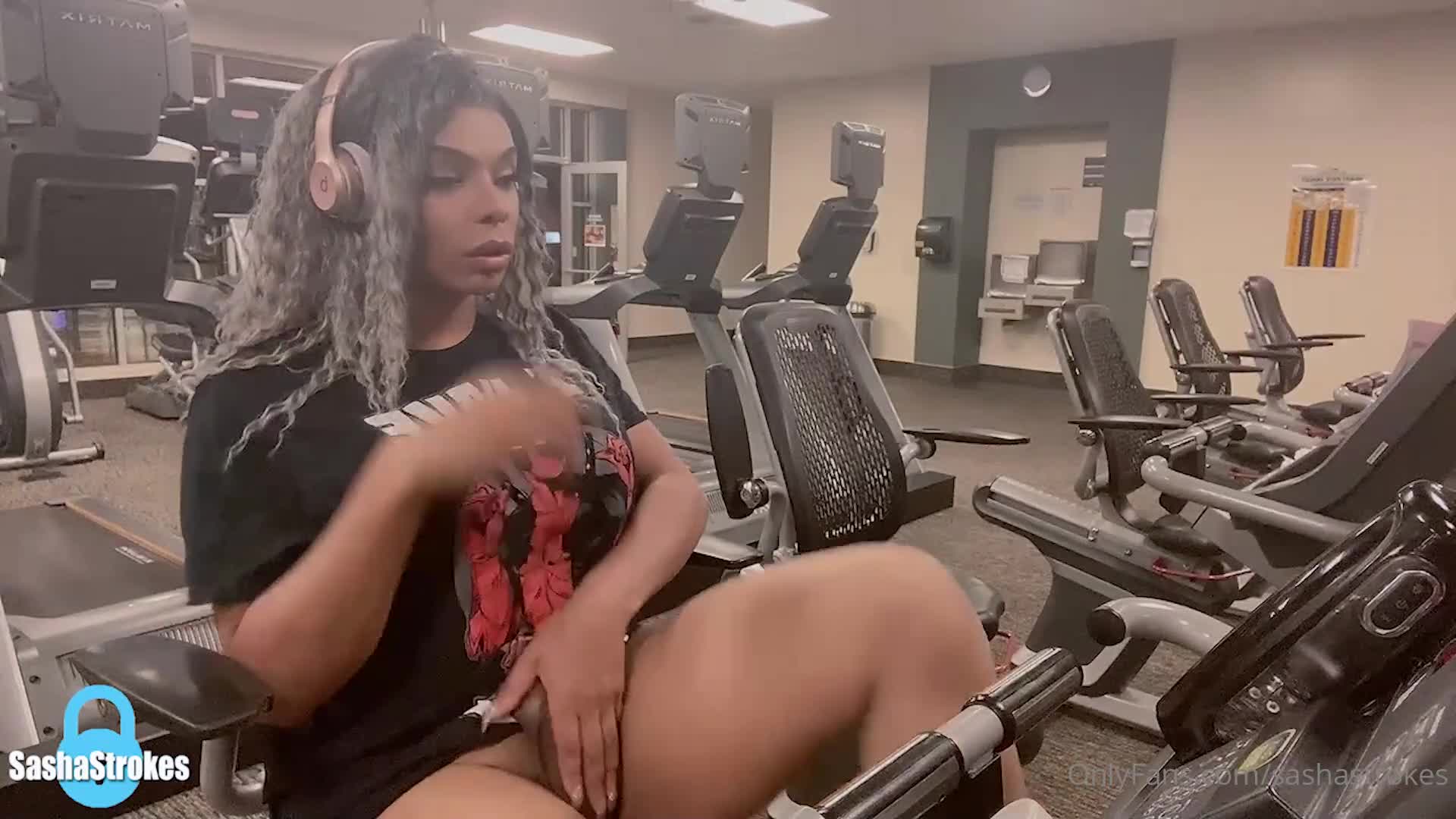 Using her sex toy to shoot a cumshot while working out in the gym